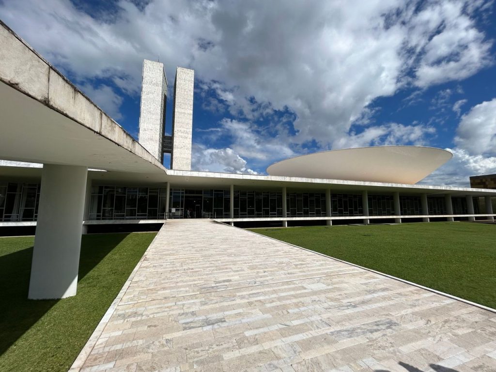 Vista da arquitetura moderna do Congresso Nacional do Brasil sob um céu claro.